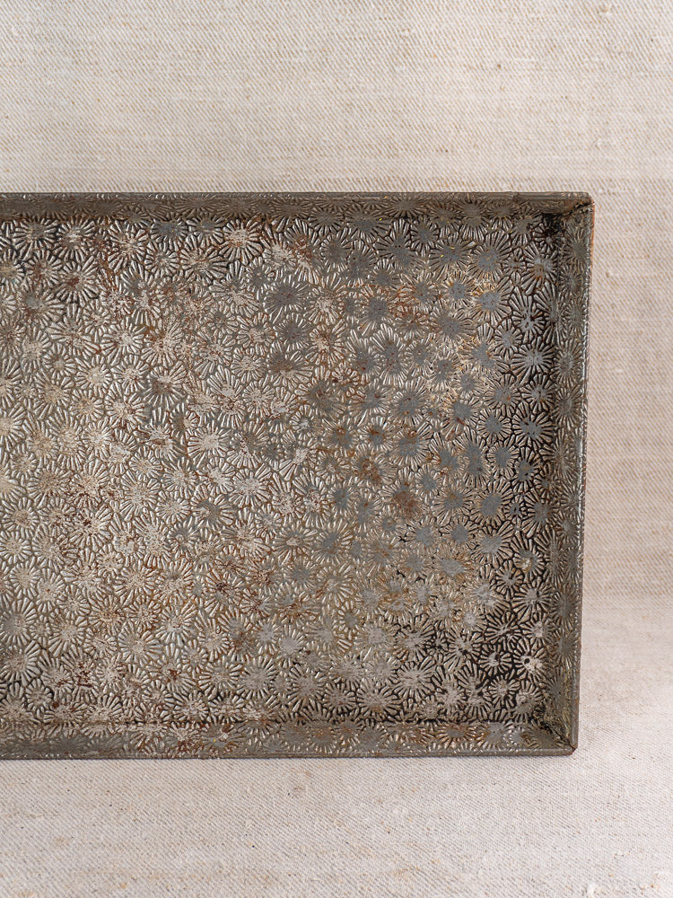 Vintage French Bakery Collection tinned steel tray, mid-20th century, ornate embossed florals, antique patina on textured fabric.