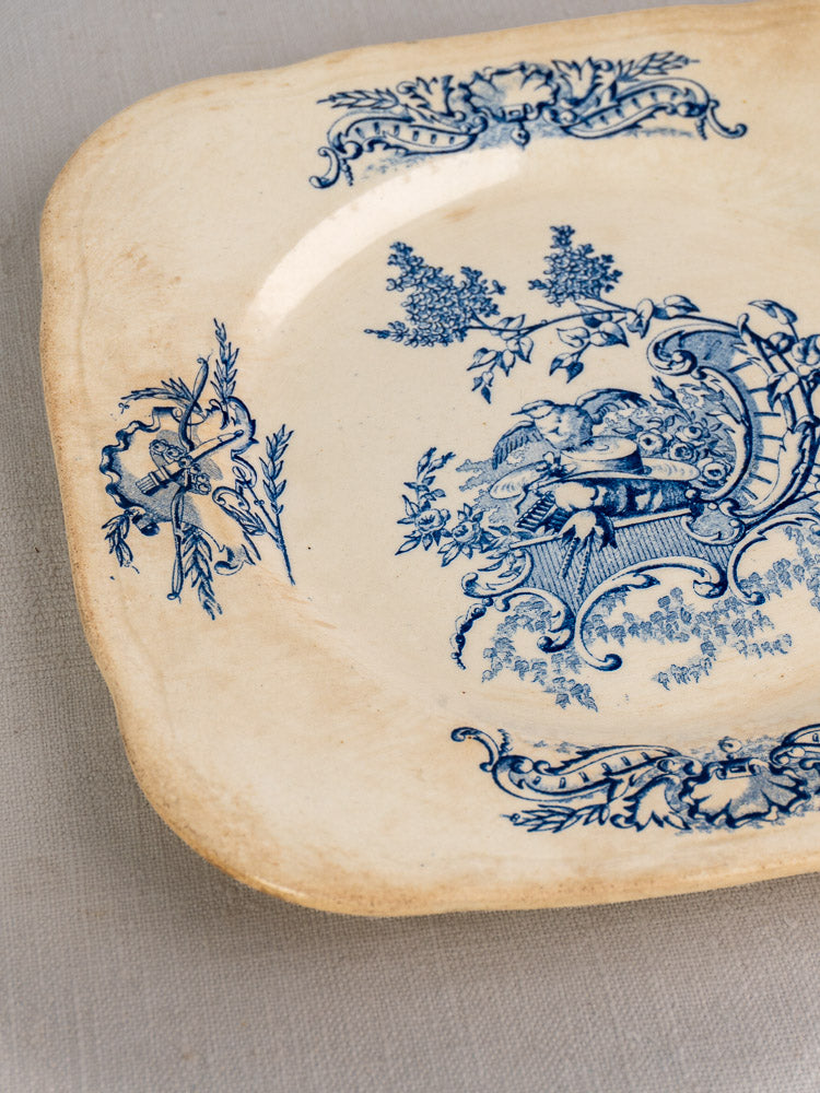 Antique French Clairefontaine plate, Louis XV Terre de Fer, blue floral scrollwork on cream, rounded edges, aged patina.