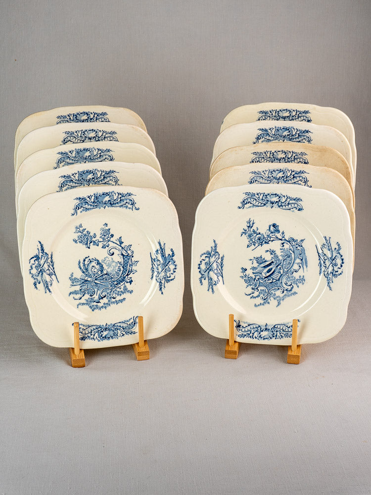 Set of ten antique French Clairefontaine Louis XV Terre de Fer plates (c. 1885) on wooden stands.