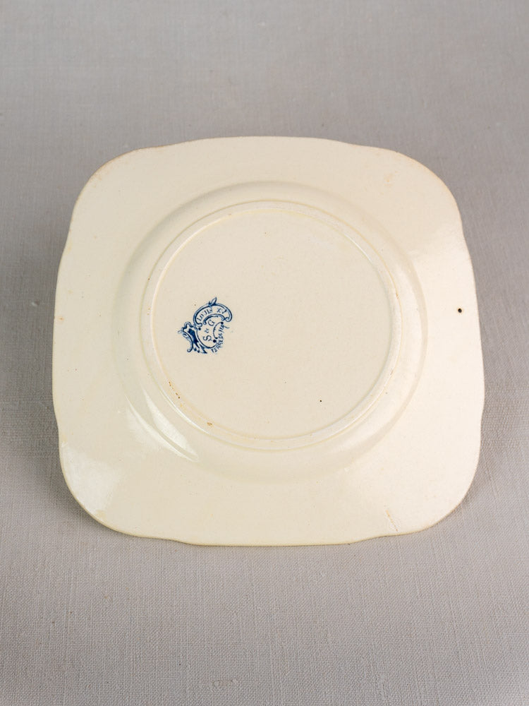 Antique French Clairefontaine Louis XV Terre de Fer plate, upside down, blue maker’s mark on cream ceramic base, gray surface.
