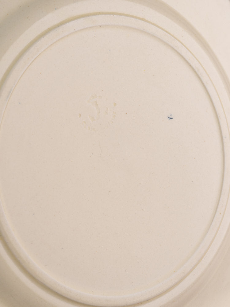 Antique French Clairefontaine plate underside with faint central maker’s mark and circular ridges near the edge.