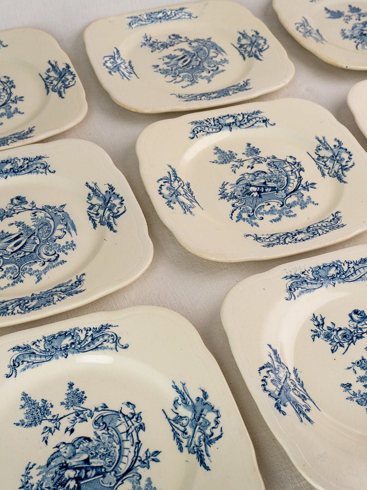 Ten vintage Clairefontaine French plates, Louis XV Terre de Fer style, with curved edges and intricate blue floral designs.