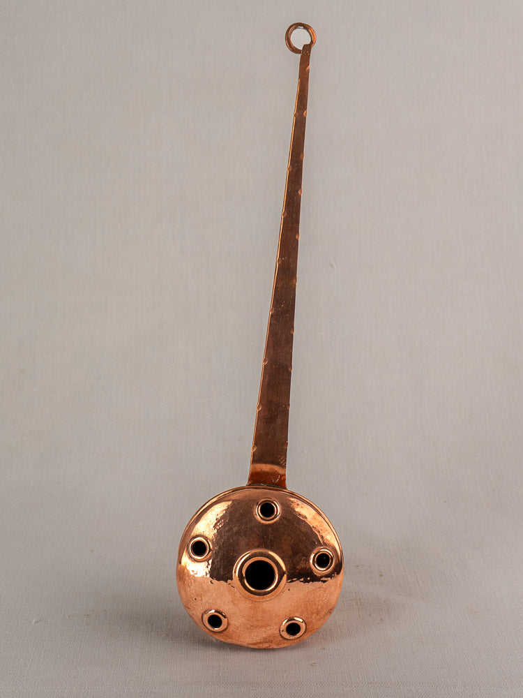 Antique French copper warming pan with long riveted handle and pierced round head, late 19th–early 20th century.