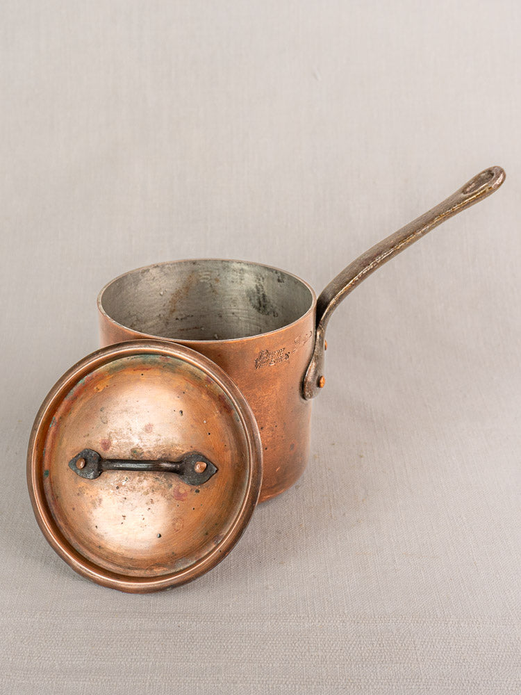Antique French copper saucepan by Pierre Vergnes Durfort, mid-20th century, with lid, on light gray surface.