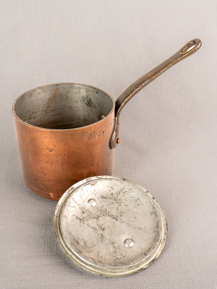 Antique French copper saucepan by Pierre Vergnes Durfort, mid-20th century, with long handle and lid on a light textured surface.