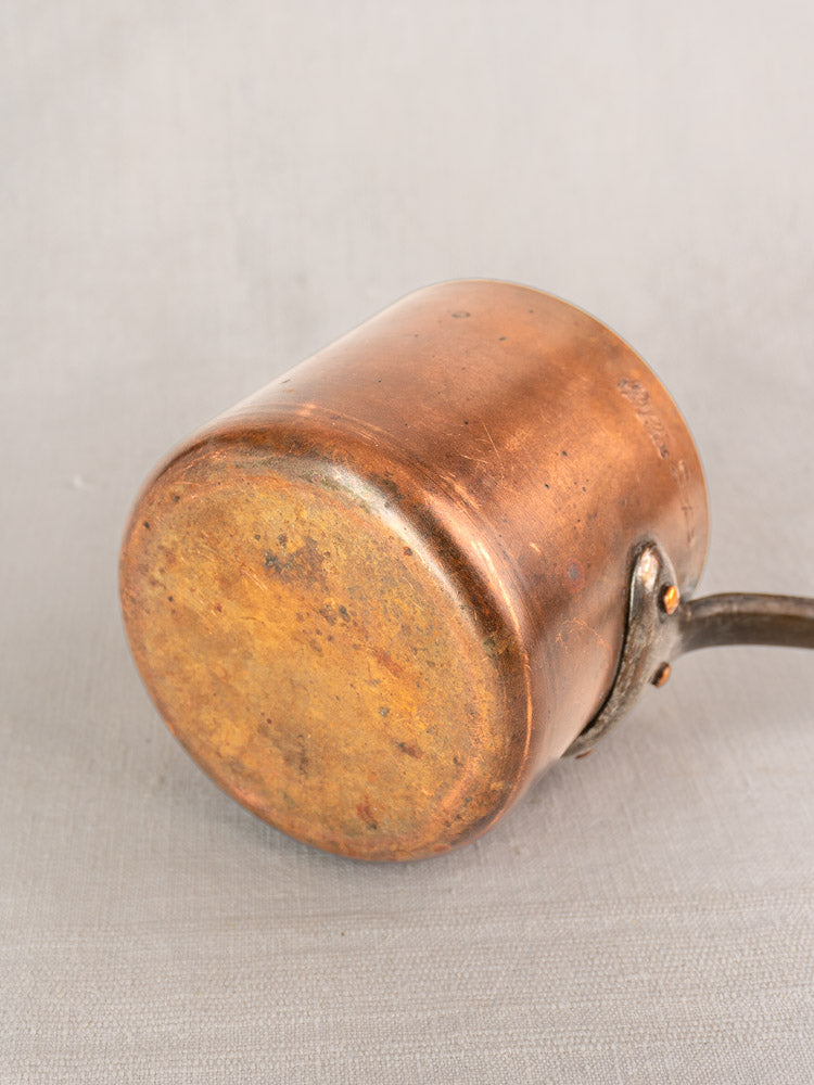 Antique French copper saucepan by Pierre Vergnes Durfort, mid 20th century, on light gray textured surface.