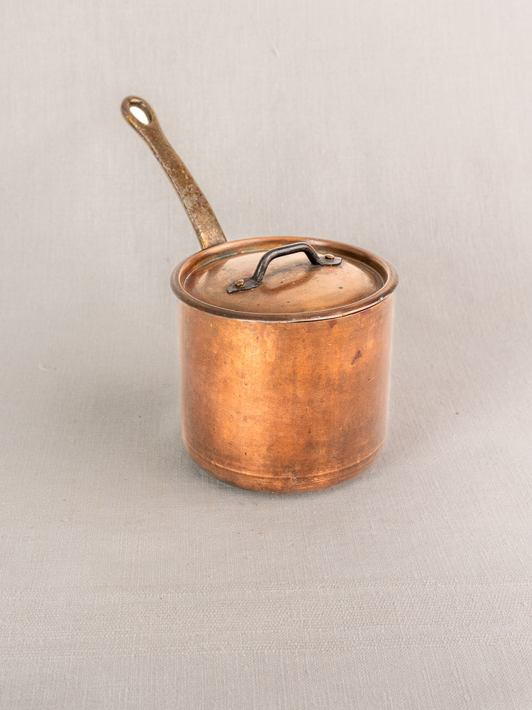Antique Pierre Vergnes Durfort French copper saucepan with lid and handle, aged patina, on light gray surface.