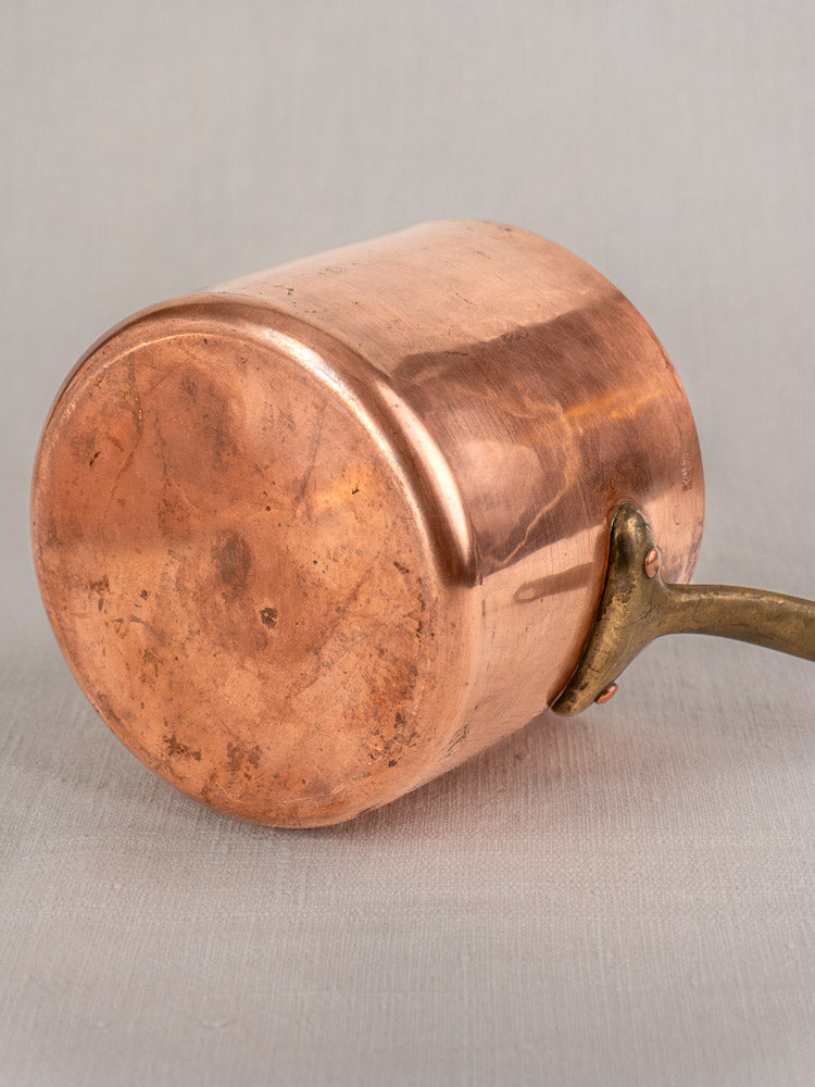 Antique French copper bain marie with Apilco porcelain insert and brass handle, scratched bottom visible, neutral gray background.