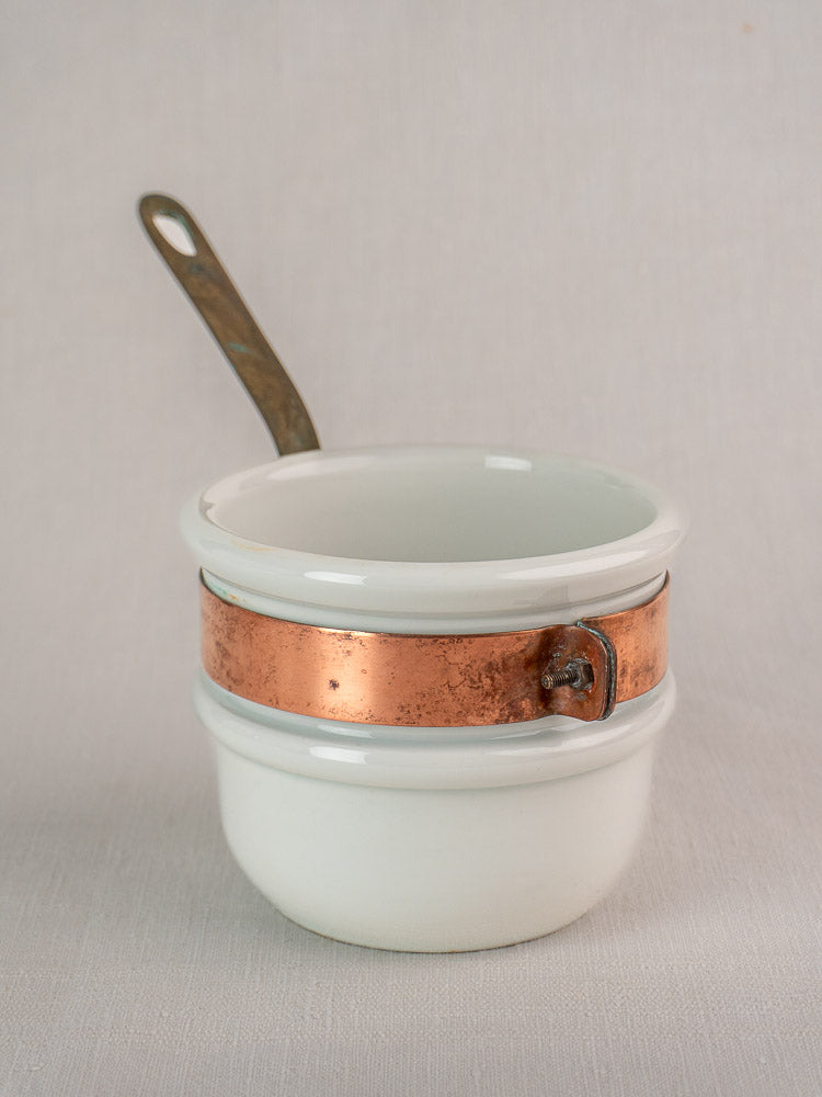 Mid-century French copper bain marie with Apilco porcelain insert and metal handle on a plain light background.