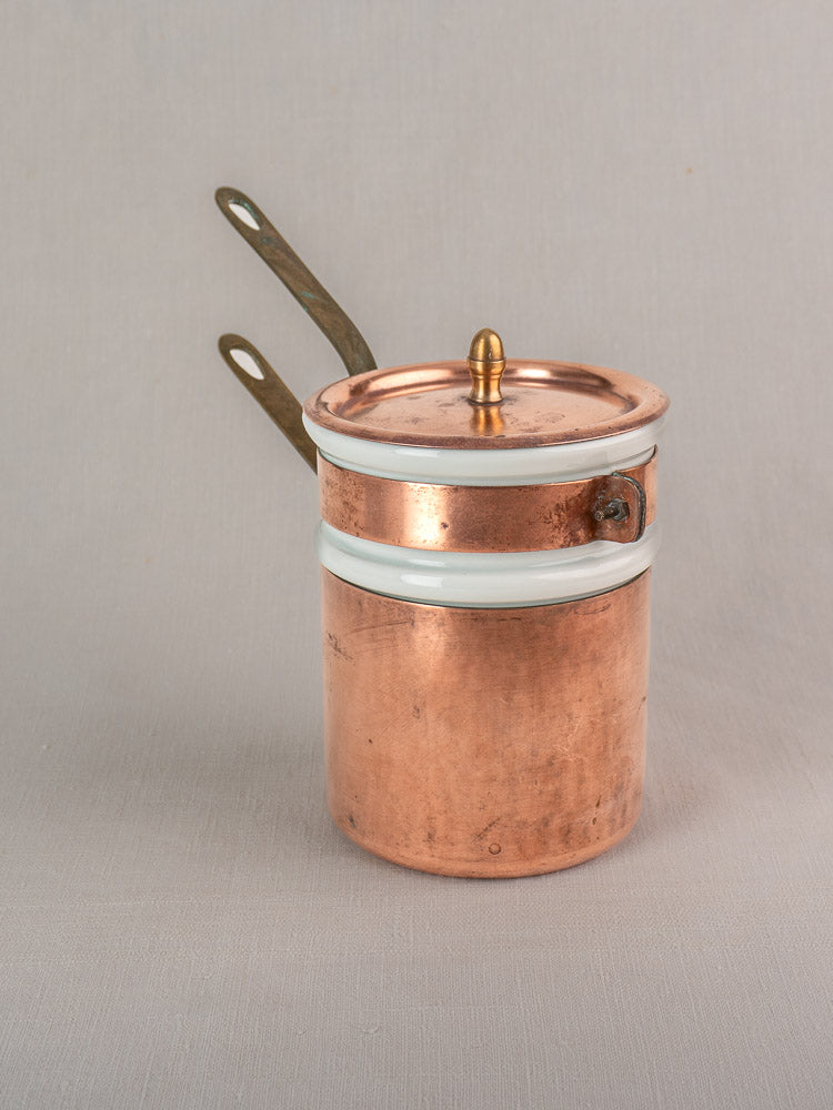 Antique French copper bain marie with brass handles, matching lid, and Apilco porcelain insert on a neutral background.