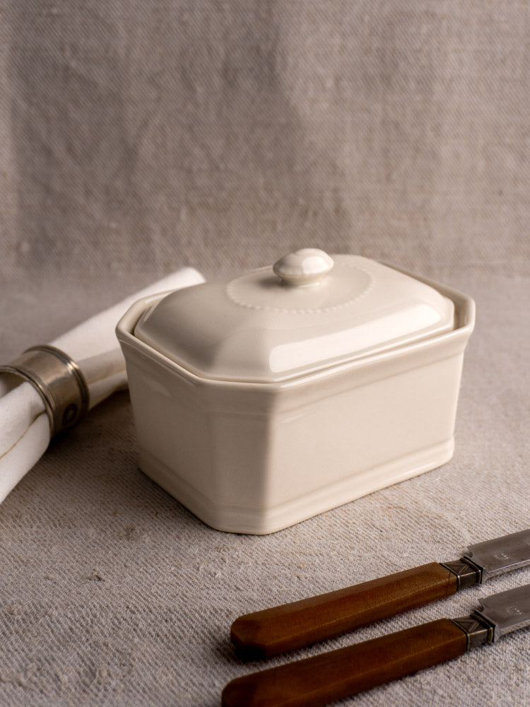 Small antique French porcelain terrine, cream-glazed with lid, round knob handle, subtle decorative details.