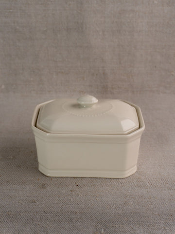 Small antique French porcelain terrine, cream-glazed with lid, round knob handle, subtle decorative details.