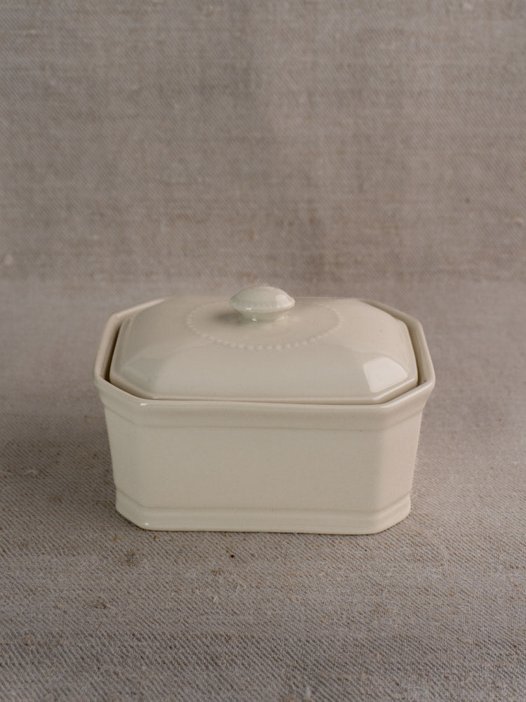 Small antique French porcelain terrine, cream-glazed with lid, round knob handle, subtle decorative details.