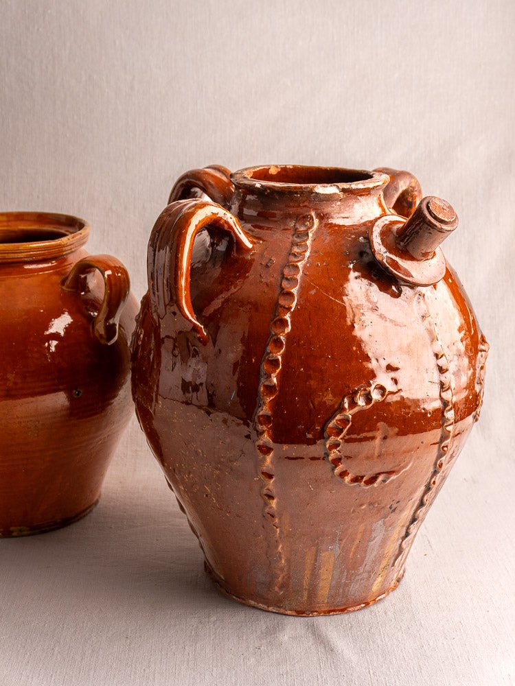 Antique French Périgord earthenware walnut oil jug with ridged detail, spout, and two handles.