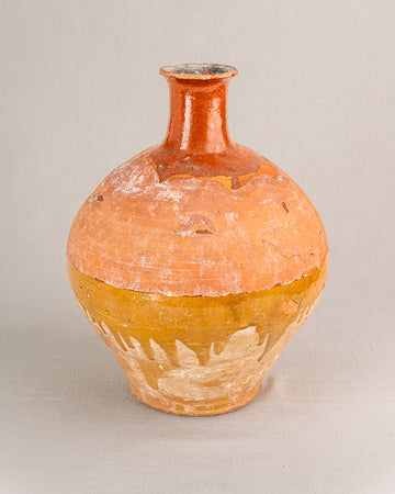 Antique French earthenware bonbonne with hand-thrown round form, bichrome glaze, subtle wear, on light gray surface.