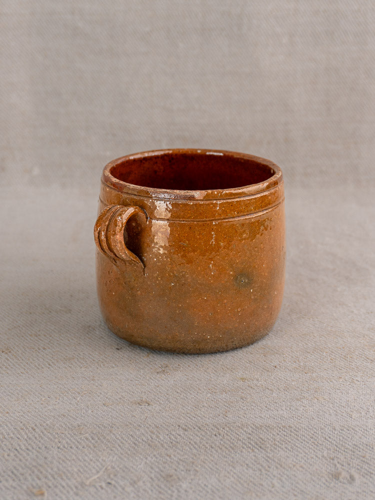 Set of three glazed terracotta pots inspired by antique French Vallauris, on beige fabric background.