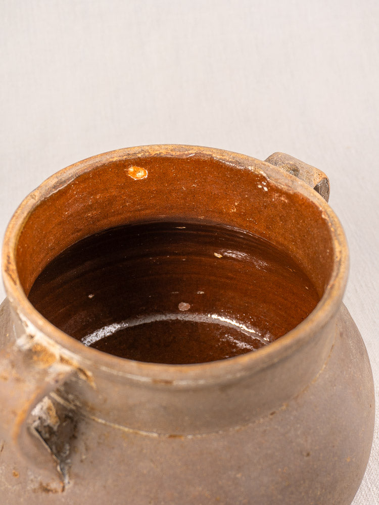 Antique French earthenware Toupin with two handles, glazed interior, and rustic weathered texture reminiscent of country pottery.