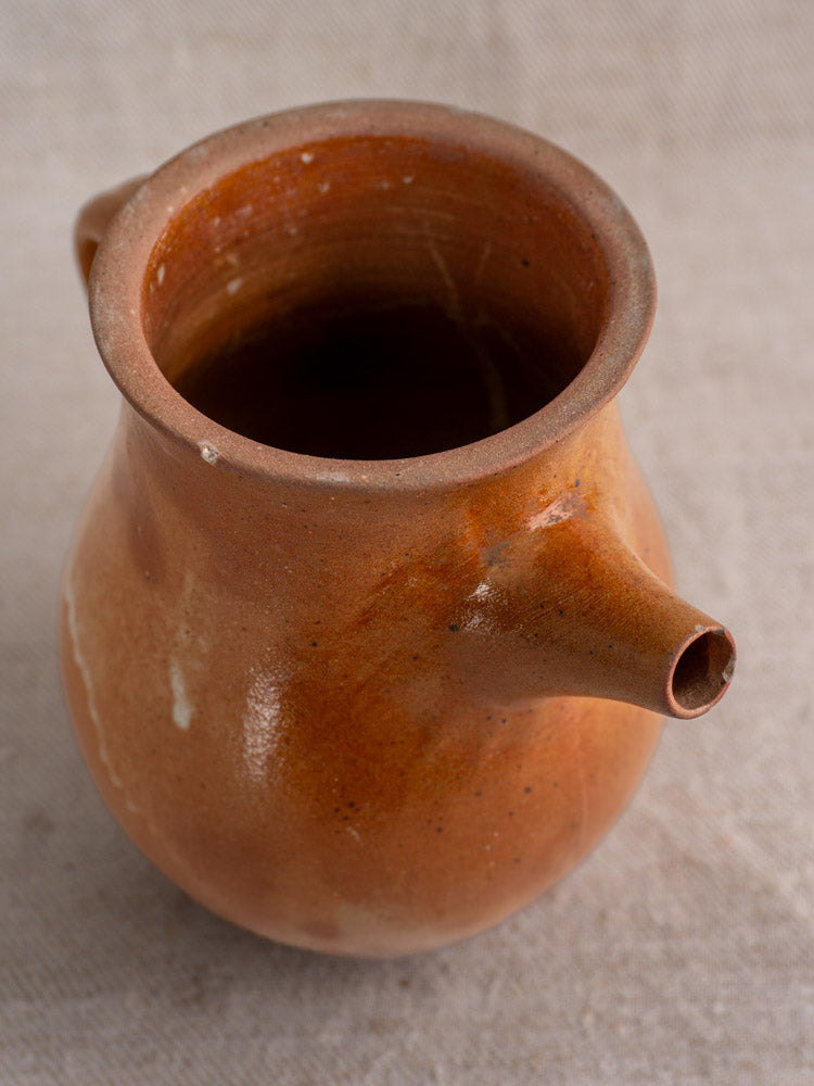 Antique French stoneware coffee pot in salt-glazed grès with infuser, mid 20th century, on beige textured fabric.