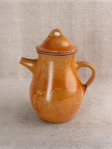 Antique French salt-glazed stoneware coffee pot with infuser, mid-20th century, on textured linen cloth.