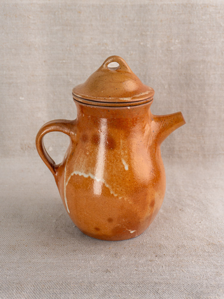 Mid-20th century French stoneware coffee pot with infuser, salt-glazed grès, on neutral textured fabric.