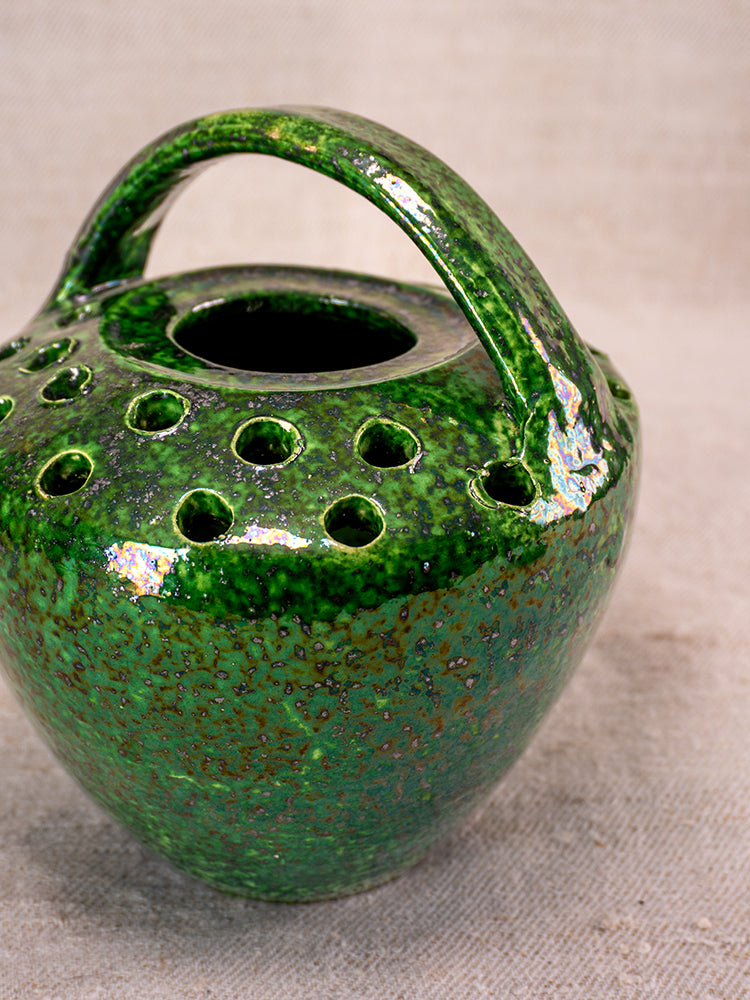 Antique French Vallauris Chaufferette, mid-20th century green glazed ember warmer with large handle, on textured fabric.