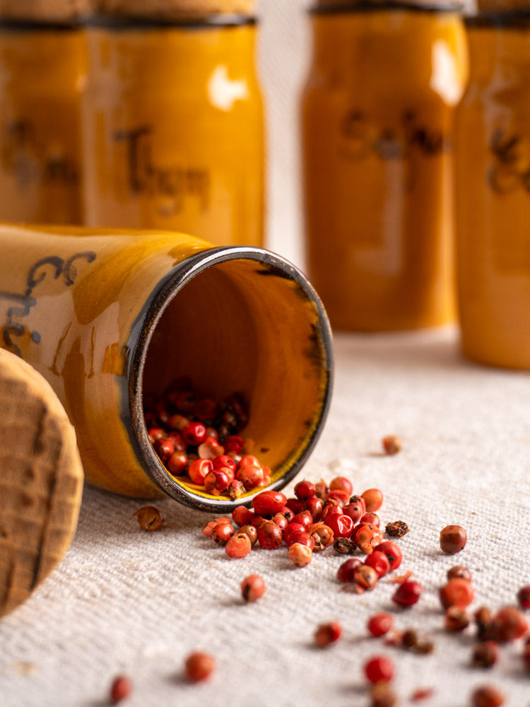 Set of 12 vintage French Vallauris yellow ceramic spice jars with cork lids and French labels.