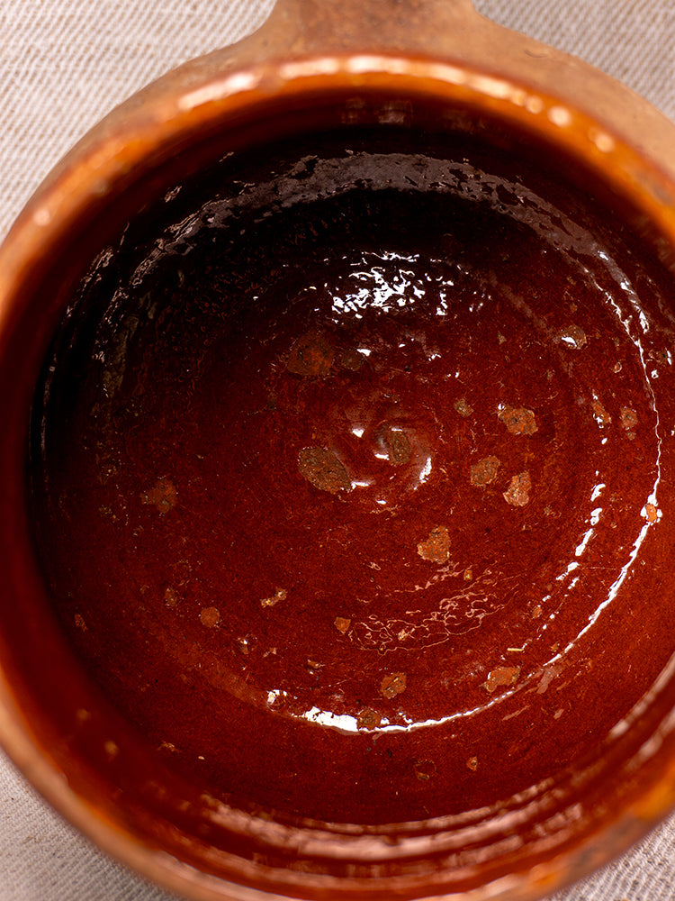 Vallauris Pot à Lait in glazed terracotta, Societe Generale stamp, glossy uneven surface with lighter spots on fabric.