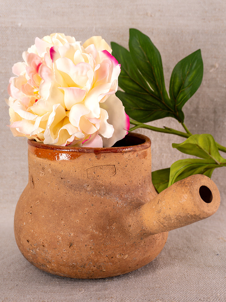Glazed terracotta Vallauris Pot à Lait with Societe Generale stamp and side spout, styled with artificial peony and green leaves.