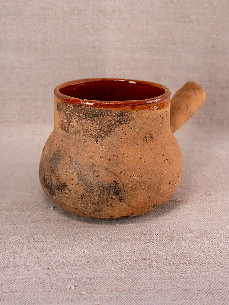 Vallauris glazed terracotta Pot à Lait with Societe Generale stamp on a light fabric surface.