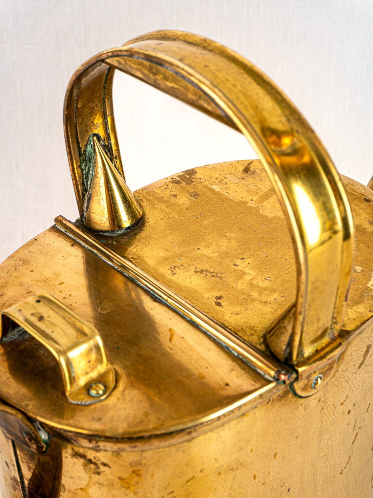 Antique French brass watering can, circa 1900, with curved handle, hinged lid, and subtle patina.