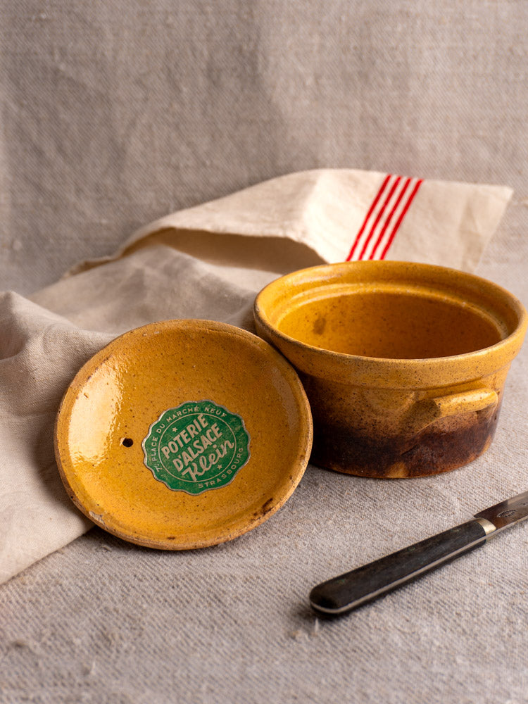 Antique French Klein Strasbourg yellow glazed earthenware cocotte with lidded top; knife placed beside pot.