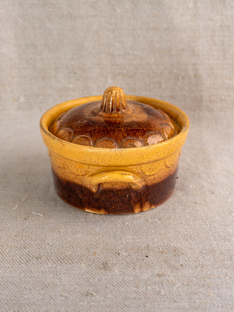 Antique French cocotte by Klein Strasbourg, early 20th century, brown and yellow Alsace glazed earthenware on beige fabric.