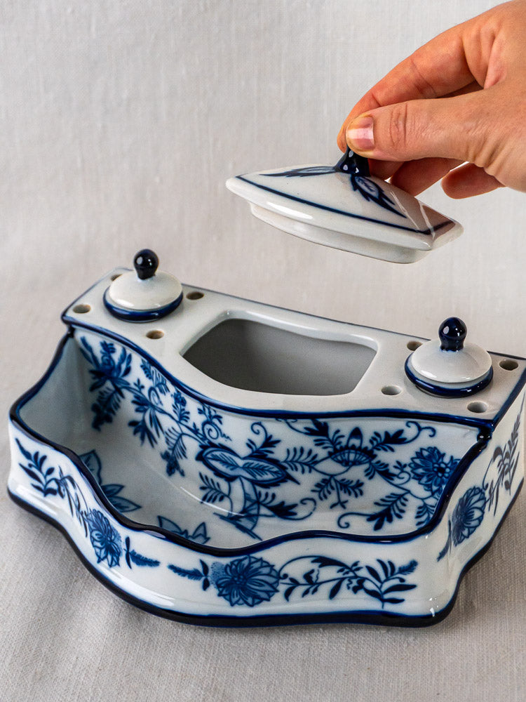 Blue and White Ironstone Inkstand with floral motifs, two ink pots, and central slot on fabric surface.