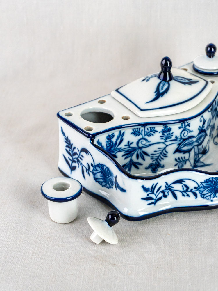 Blue and white ironstone inkstand with Blue Onion floral motifs, two ink containers, on fabric background.