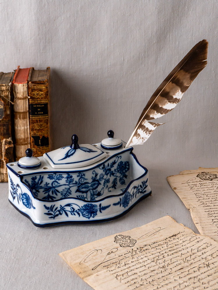 Blue and white ironstone inkstand with Blue Onion motifs, paired with quill, letters, and vintage books.