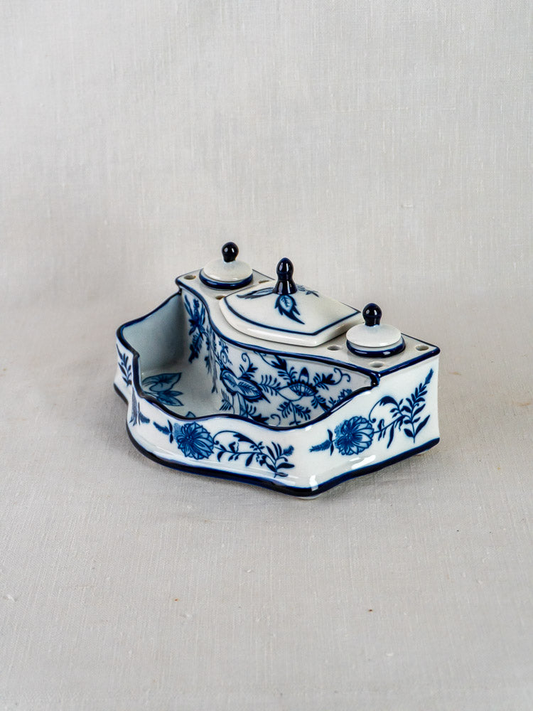 Blue and white ironstone inkstand with floral motifs, twin lidded containers, and central tray on curved base.