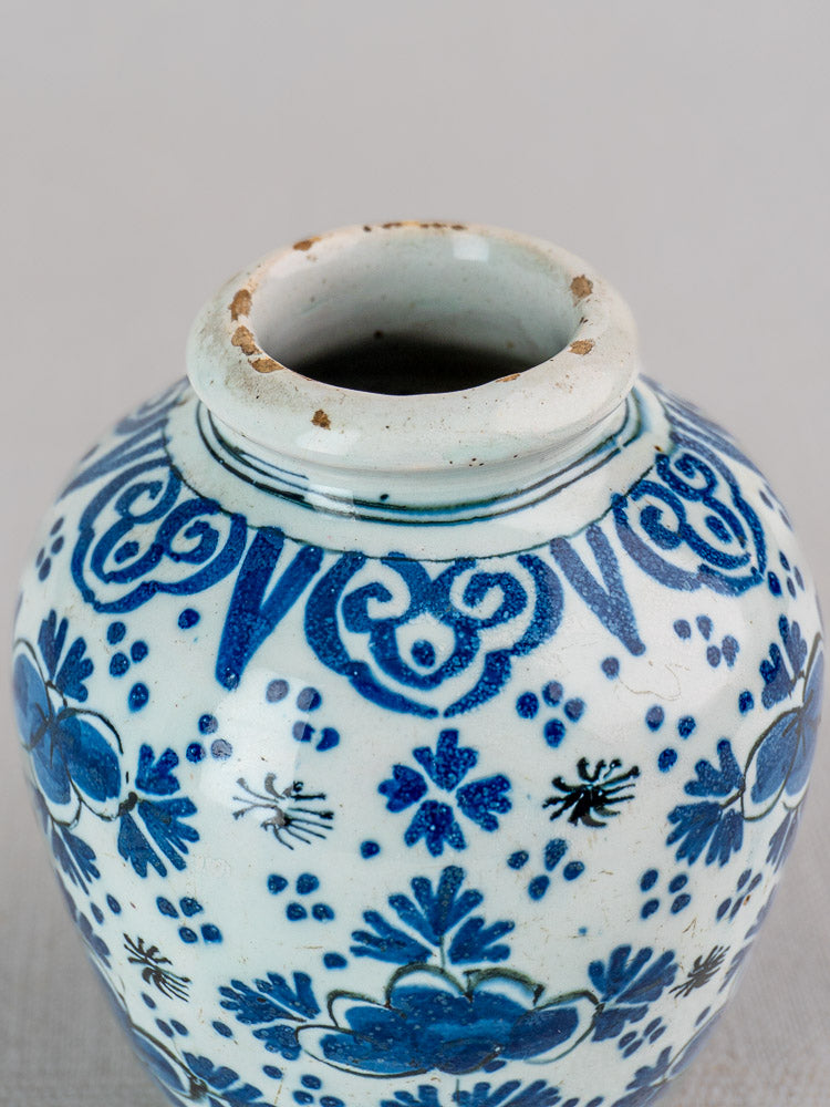 Antique 18th-century Dutch Delft blue and white faience vase rim with floral and geometric motifs, showing minor rim wear.