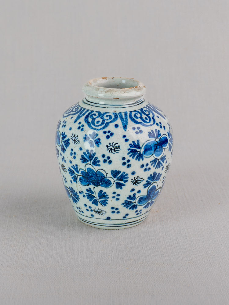 Antique Dutch Delft faience vase with blue chinoiserie floral patterns, wide opening, on a light gray background.