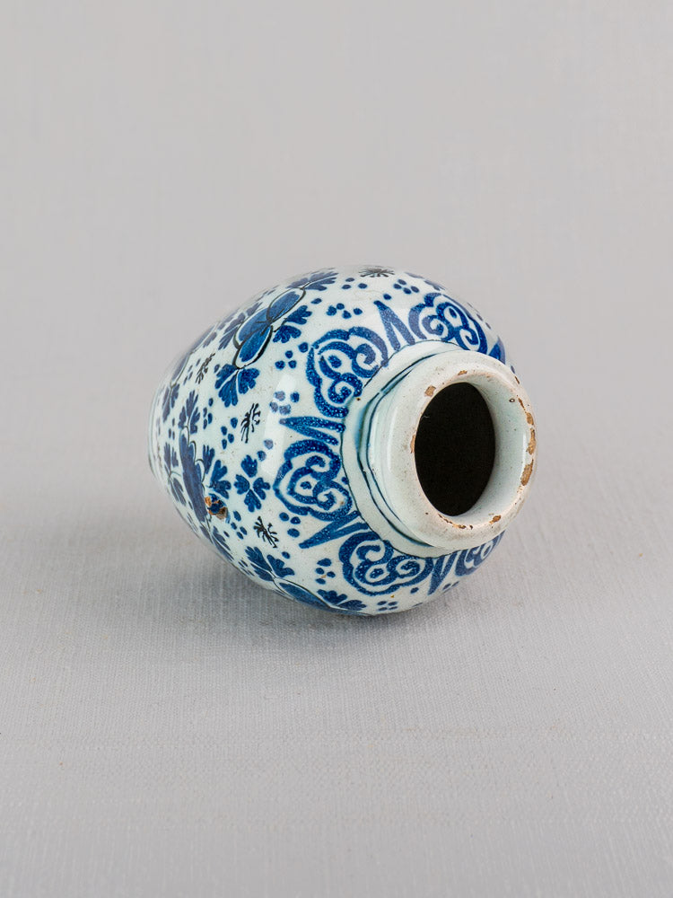 18th century blue and white Dutch Delft faience vase features floral and geometric motifs on a pale gray background.