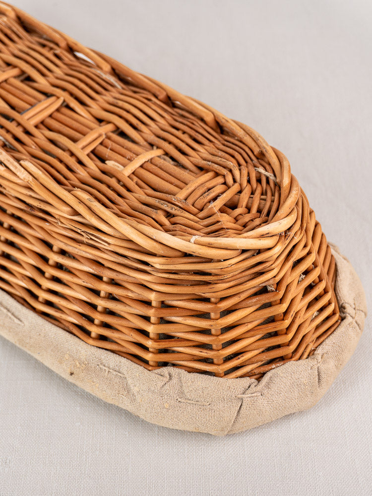Vintage French baguette proofing basket with linen liner, circa 1940-1950, showcasing classic bread-making craftsmanship.