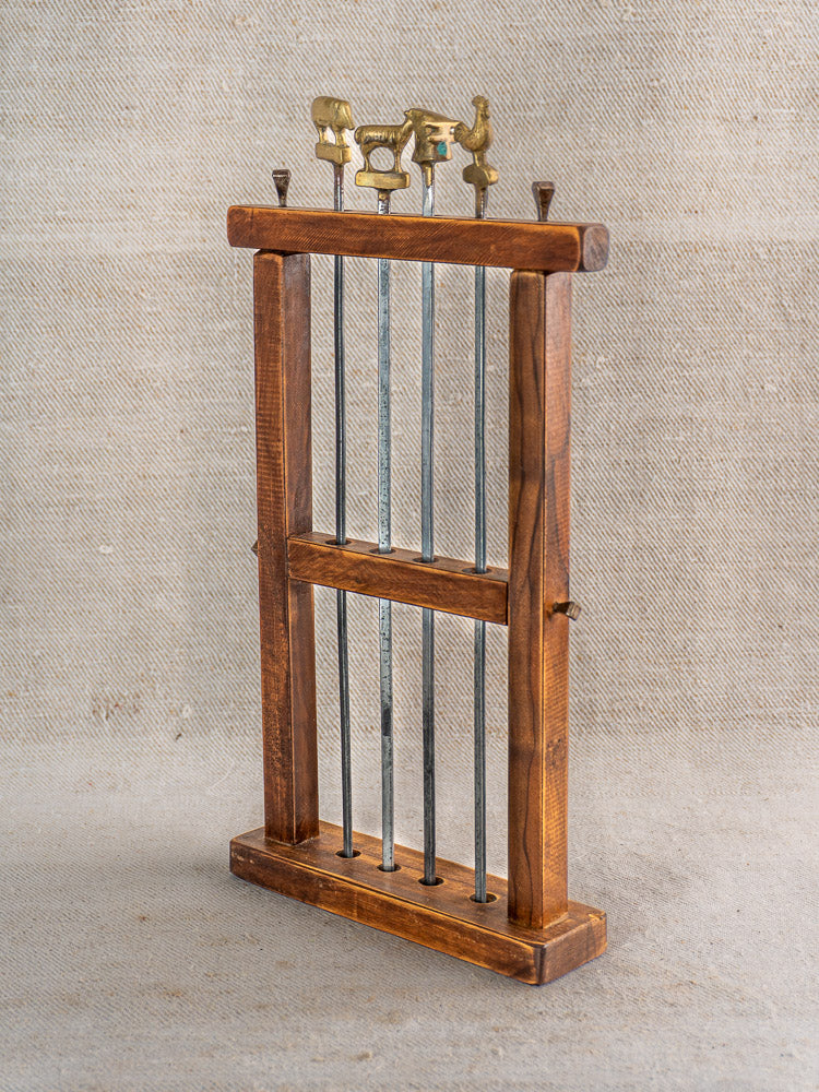 Vintage French brochette skewers set with brass animal finials in a rectangular wooden stand.