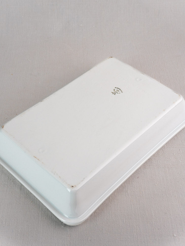 Vintage French porcelain baking dish, white rectangular, upside down showing small marks and black number on base.