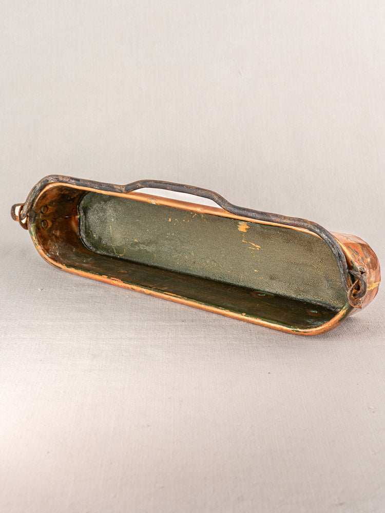 Antique French copper poissonniere, oval with single handle, empty and angled to display interior and aged patina.