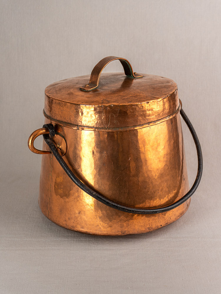 Hand-hammered antique French copper cauldron with lid and black metal swing handles, 19th-century marmite.