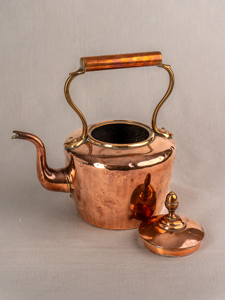 Late 19th century French copper tea kettle with wood handle, lid off and open top, displayed on a neutral surface.