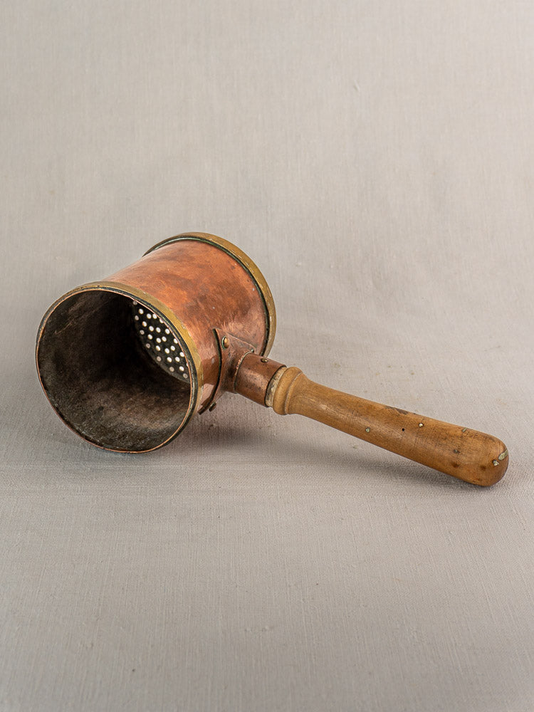 Vintage metal and wood rotary cheese grater next to antique French copper strainer pot, L. Fraiche Carcassonne.