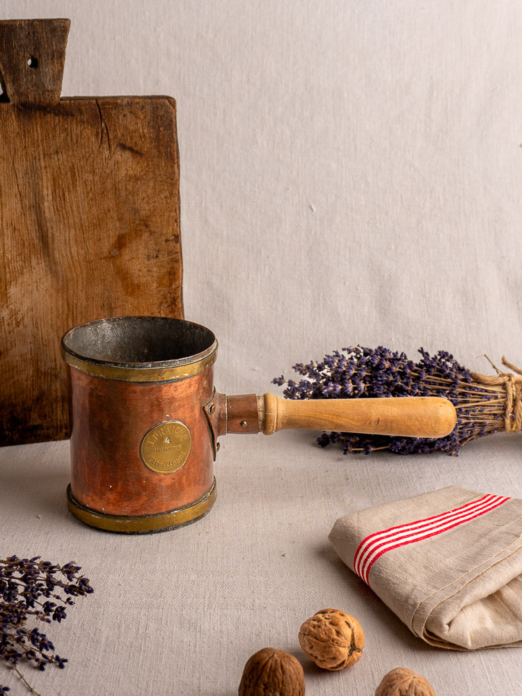Antique French copper strainer pot by L. Fraiche Carcassonne on cloth with rustic board, dried lavender, and walnuts.