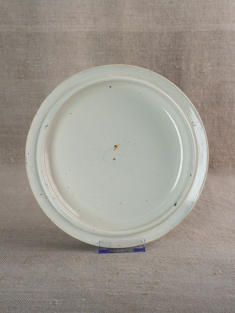 Antique French Saint-Amand faience tureen with fruit pattern on neutral textured fabric background.