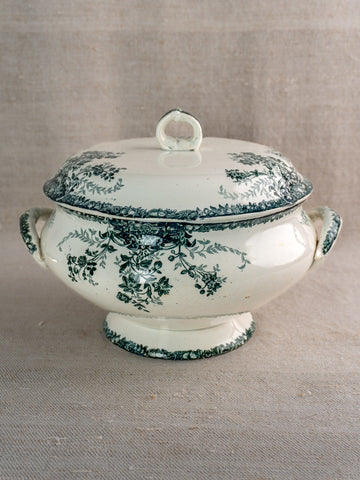 Antique French Saint-Amand white faience soupière with lid, green fruits pattern, on neutral fabric.