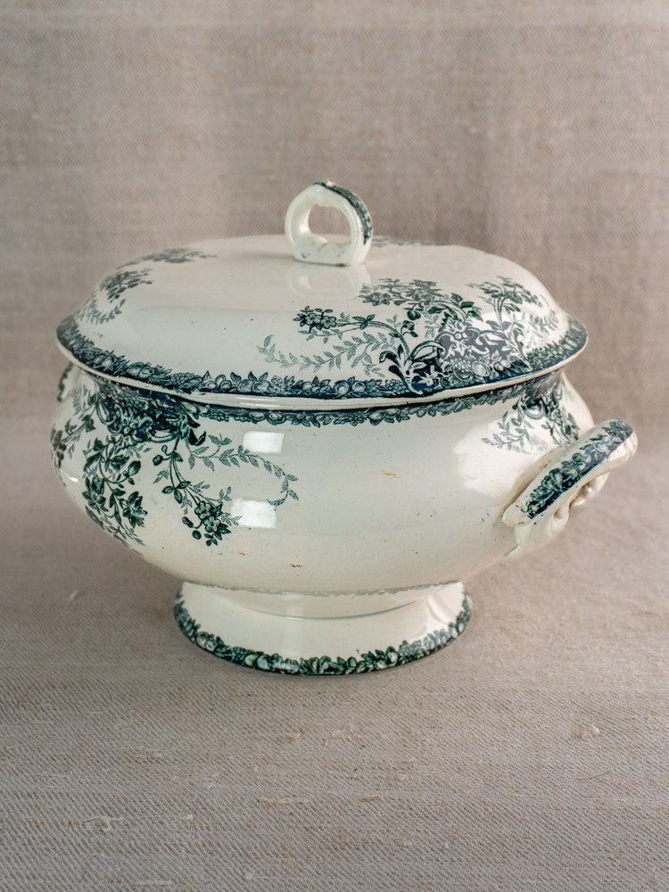 Antique French Saint-Amand faience soupière with lid and handles, black fruit motif, on beige fabric.